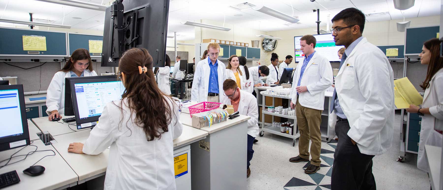 Researchers working at different stations in a lab.