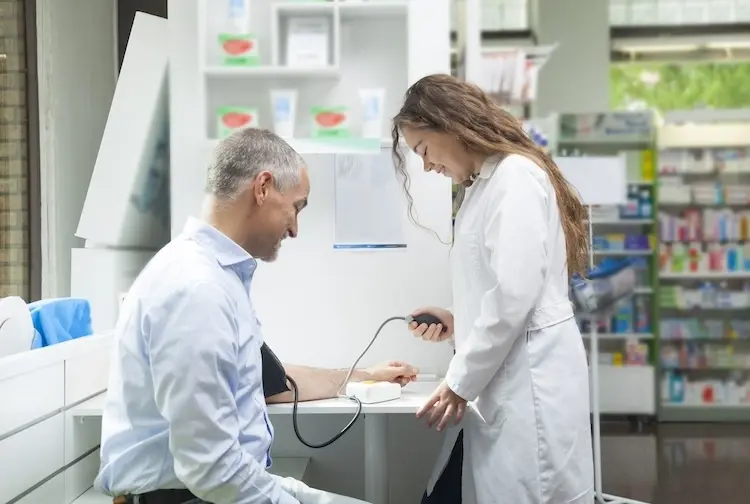 A photo of a pharmacist taking a patient's blood pressure.