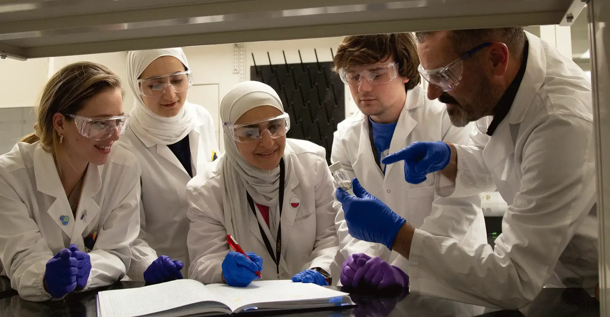 students in a lab writing in notebook